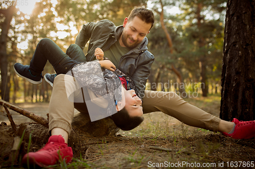 Image of Father and son walking and having fun in autumn forest, look happy and sincere