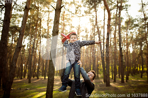 Image of Father and son walking and having fun in autumn forest, look happy and sincere