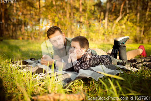 Image of Father and son walking and having fun in autumn forest, look happy and sincere