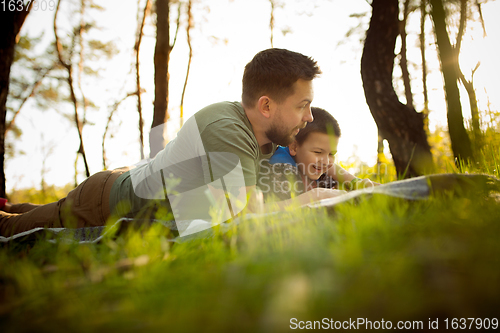 Image of Father and son walking and having fun in autumn forest, look happy and sincere