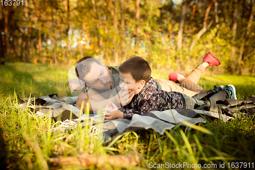 Image of Father and son walking and having fun in autumn forest, look happy and sincere