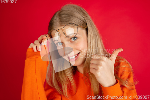 Image of Portrait of young caucasian woman with bright emotions isolated on red studio background