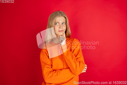 Image of Portrait of young caucasian woman with bright emotions isolated on red studio background