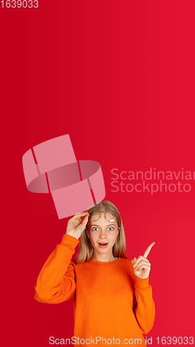 Image of Portrait of young caucasian woman with bright emotions isolated on red studio background