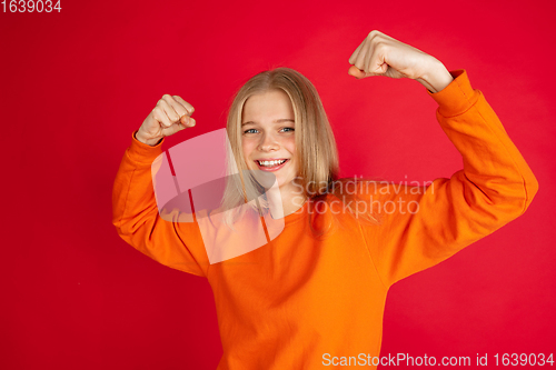 Image of Portrait of young caucasian woman with bright emotions isolated on red studio background