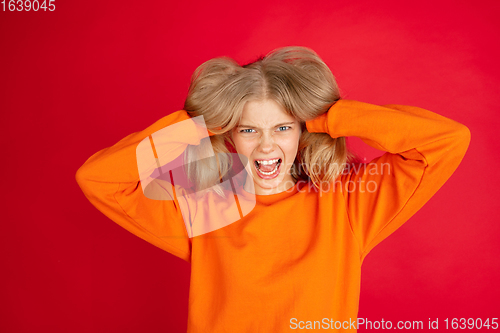 Image of Portrait of young caucasian woman with bright emotions isolated on red studio background
