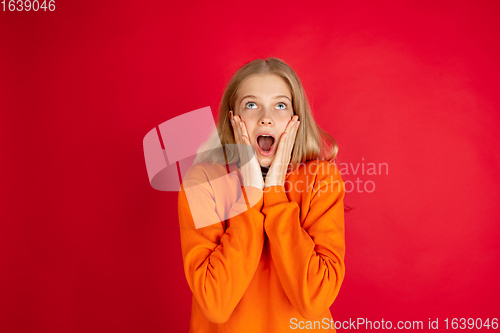 Image of Portrait of young caucasian woman with bright emotions isolated on red studio background