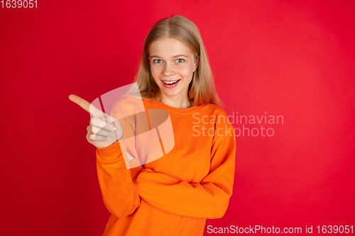 Image of Portrait of young caucasian woman with bright emotions isolated on red studio background