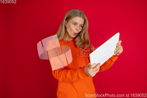 Image of Portrait of young caucasian woman with bright emotions isolated on red studio background