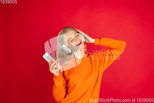 Image of Portrait of young caucasian woman with bright emotions isolated on red studio background