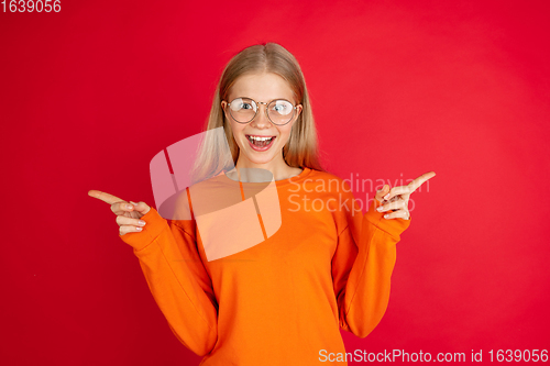 Image of Portrait of young caucasian woman with bright emotions isolated on red studio background