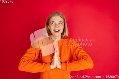 Image of Portrait of young caucasian woman with bright emotions isolated on red studio background