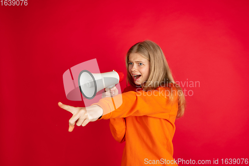 Image of Portrait of young caucasian woman with bright emotions isolated on red studio background