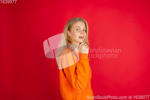 Image of Portrait of young caucasian woman with bright emotions isolated on red studio background