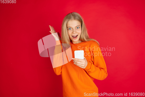 Image of Portrait of young caucasian woman with bright emotions isolated on red studio background