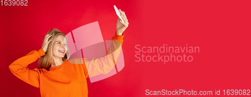 Image of Portrait of young caucasian woman with bright emotions isolated on red studio background