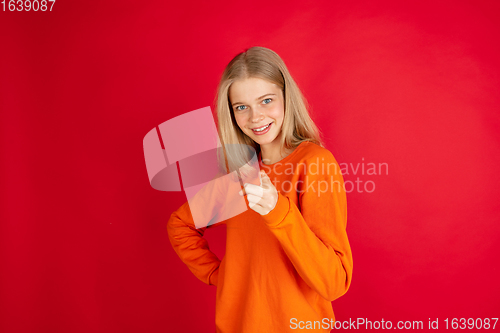 Image of Portrait of young caucasian woman with bright emotions isolated on red studio background