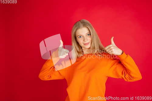 Image of Portrait of young caucasian woman with bright emotions isolated on red studio background