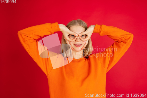 Image of Portrait of young caucasian woman with bright emotions isolated on red studio background