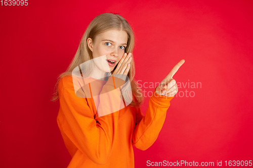 Image of Portrait of young caucasian woman with bright emotions isolated on red studio background