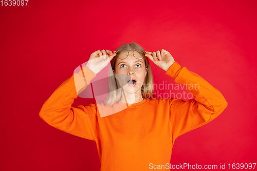 Image of Portrait of young caucasian woman with bright emotions isolated on red studio background