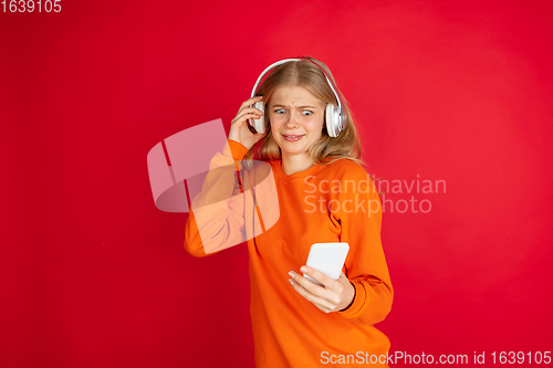 Image of Portrait of young caucasian woman with bright emotions isolated on red studio background