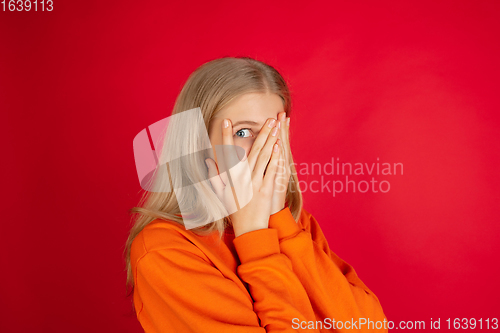 Image of Portrait of young caucasian woman with bright emotions isolated on red studio background