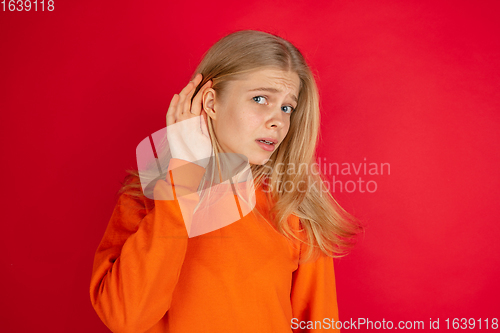 Image of Portrait of young caucasian woman with bright emotions isolated on red studio background