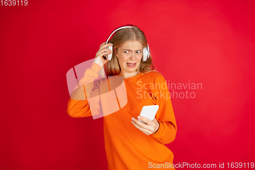 Image of Portrait of young caucasian woman with bright emotions isolated on red studio background