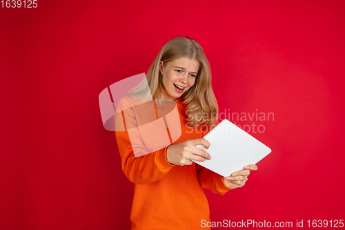 Image of Portrait of young caucasian woman with bright emotions isolated on red studio background