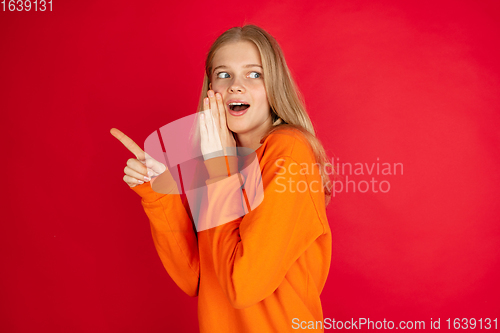 Image of Portrait of young caucasian woman with bright emotions isolated on red studio background