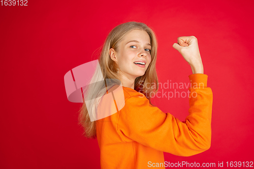 Image of Portrait of young caucasian woman with bright emotions isolated on red studio background