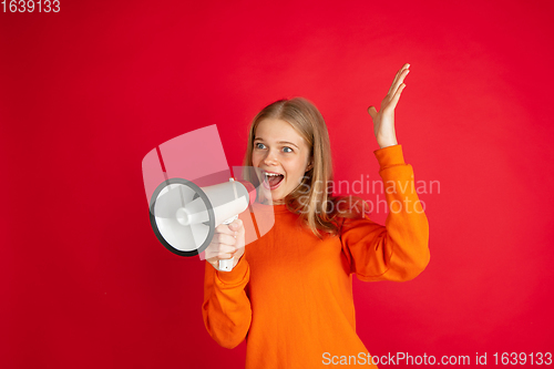 Image of Portrait of young caucasian woman with bright emotions isolated on red studio background