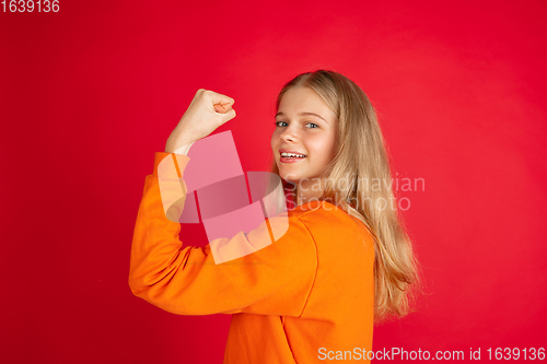 Image of Portrait of young caucasian woman with bright emotions isolated on red studio background