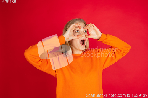 Image of Portrait of young caucasian woman with bright emotions isolated on red studio background