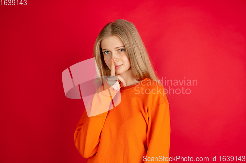 Image of Portrait of young caucasian woman with bright emotions isolated on red studio background