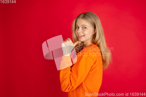 Image of Portrait of young caucasian woman with bright emotions isolated on red studio background