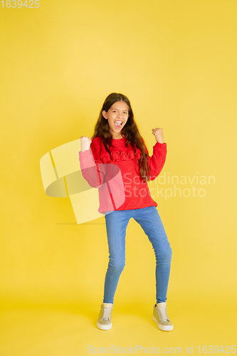 Image of Portrait of young caucasian teen girl with bright emotions isolated on yellow studio background