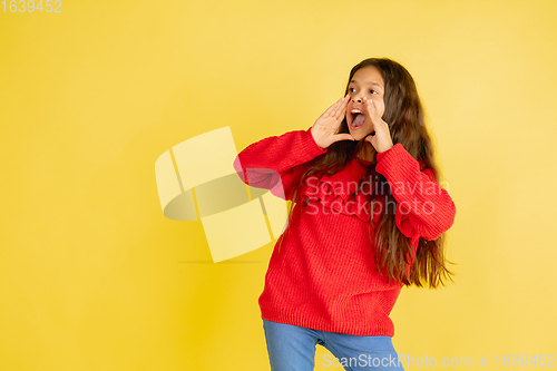 Image of Portrait of young caucasian teen girl with bright emotions isolated on yellow studio background