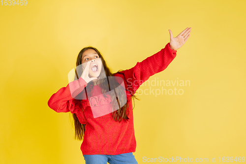 Image of Portrait of young caucasian teen girl with bright emotions isolated on yellow studio background