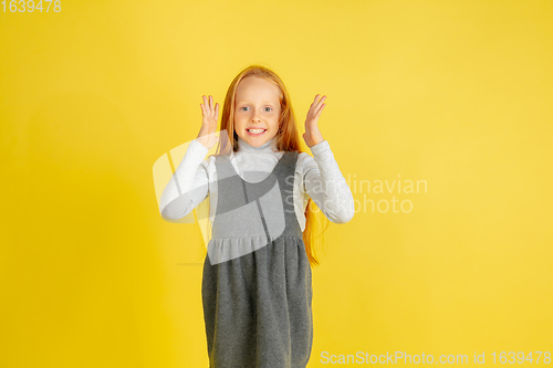 Image of Portrait of little caucasian girl with bright emotions isolated on yellow studio background