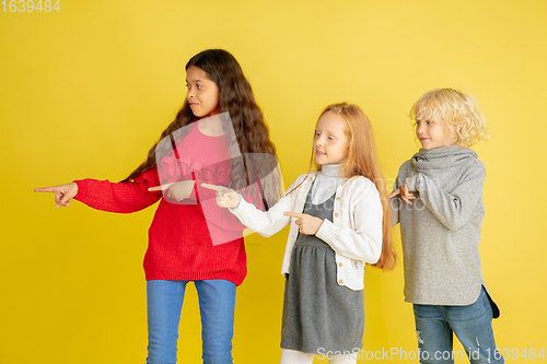 Image of Portrait of little caucasian children with bright emotions isolated on yellow studio background