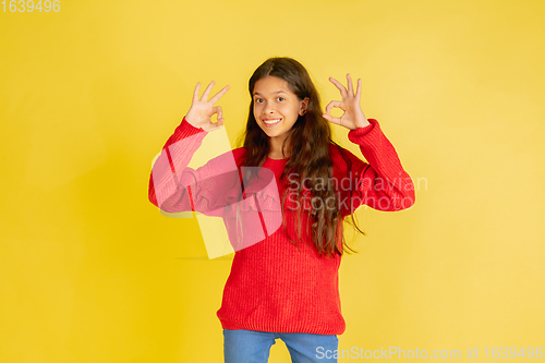 Image of Portrait of young caucasian teen girl with bright emotions isolated on yellow studio background