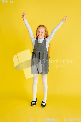 Image of Portrait of little caucasian girl with bright emotions isolated on yellow studio background