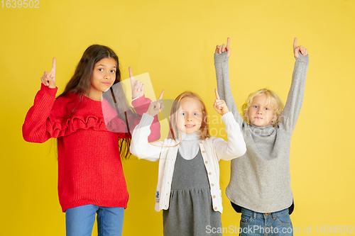 Image of Portrait of little caucasian children with bright emotions isolated on yellow studio background