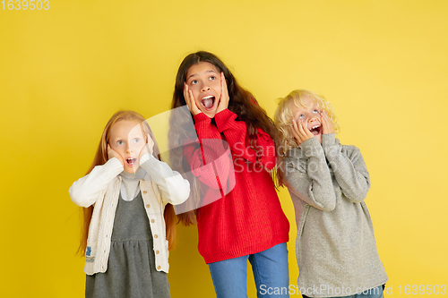 Image of Portrait of little caucasian children with bright emotions isolated on yellow studio background