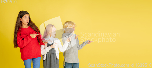 Image of Portrait of little caucasian children with bright emotions isolated on yellow studio background