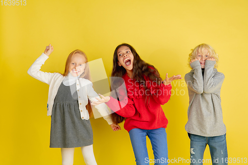 Image of Portrait of little caucasian children with bright emotions isolated on yellow studio background