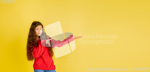 Image of Portrait of young caucasian teen girl with bright emotions isolated on yellow studio background