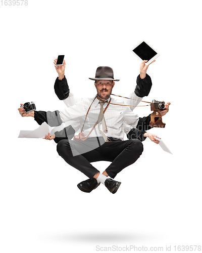 Image of Handsome multi-armed journalist levitating isolated on yellow studio background with equipment